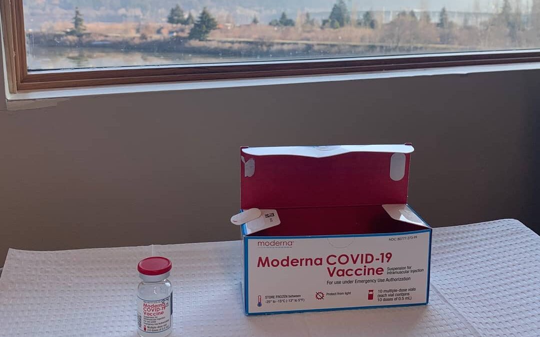 COVID vaccine box sitting on table with mountain view out the window