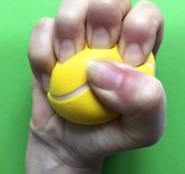 Man's Hand Squeezing Yellow Stress Ball