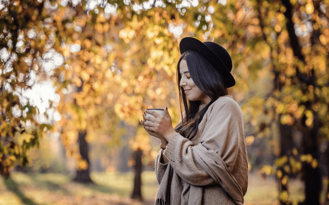 Woman holding tea outside in the fall