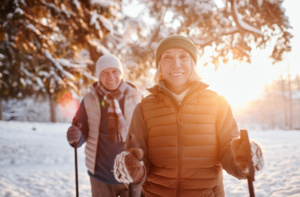 Older couple walking through snowy woods